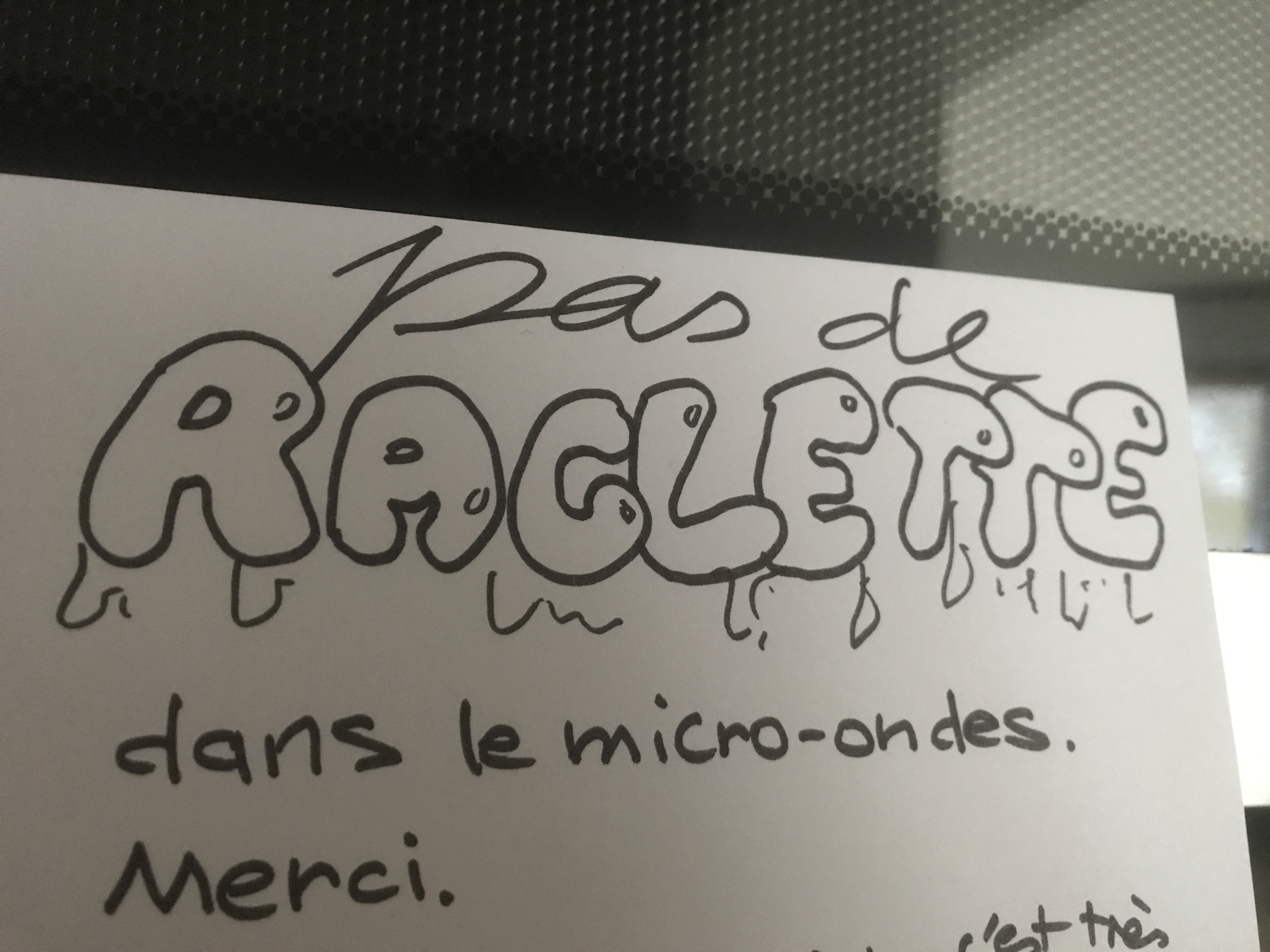 Photo d'un petit mot dessiné/écrit et posé devant le micro-ondes : « Pas de raclette dans le micro-ondes. Merci. »